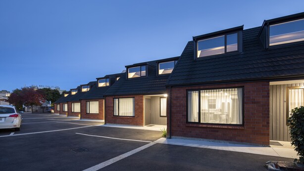 A row of modern houses with large windows and a parking lot in front. - Dunedin Motel and Villas (Dunedin)