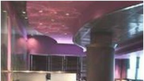 A restaurant with a long table set for dining, high ceilings, and modern lighting. - Savoy Suites (Noida)