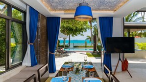 A dining area with a view of the sea, a TV, and a pool. - The Sea Koh Samui Resort & Residences by Tolani (Koh Samui)