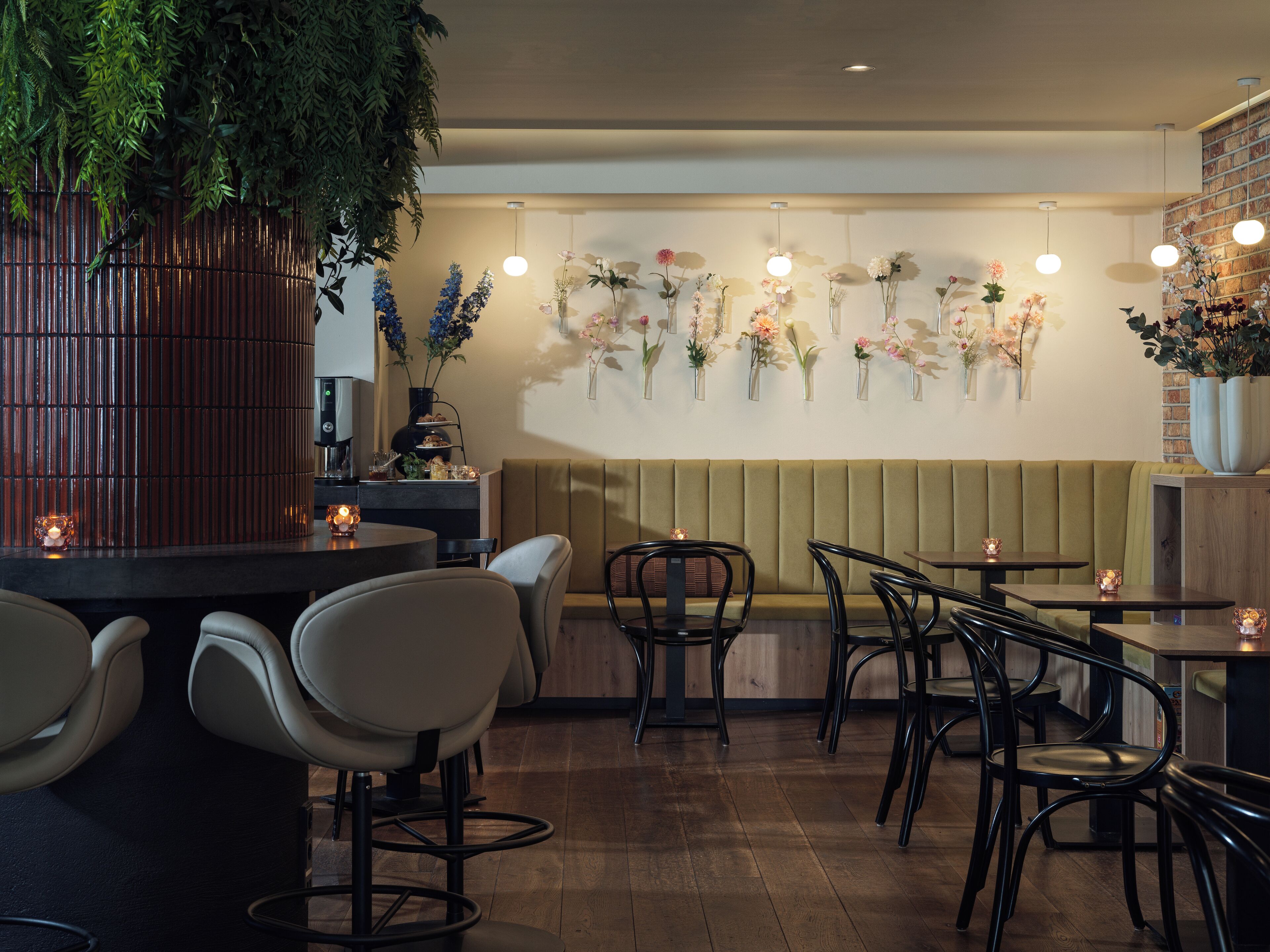 L’intérieur d’un restaurant, avec des banquettes, des tables rondes et des chaises.