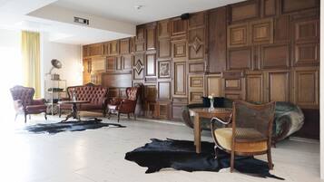 Un amplio salón con un gran panel de madera, sofás de cuero y una alfombra de cuero negro.