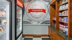 A kitchen area with a refrigerator, freezer, and shelves stocked with snacks and drinks. - Hampton Inn & Suites Clovis-Airport North (Clovis)