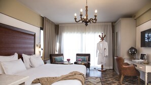 Una habitación de hotel con una cama grande, un escritorio, una silla, un globo terráqueo y un televisor.