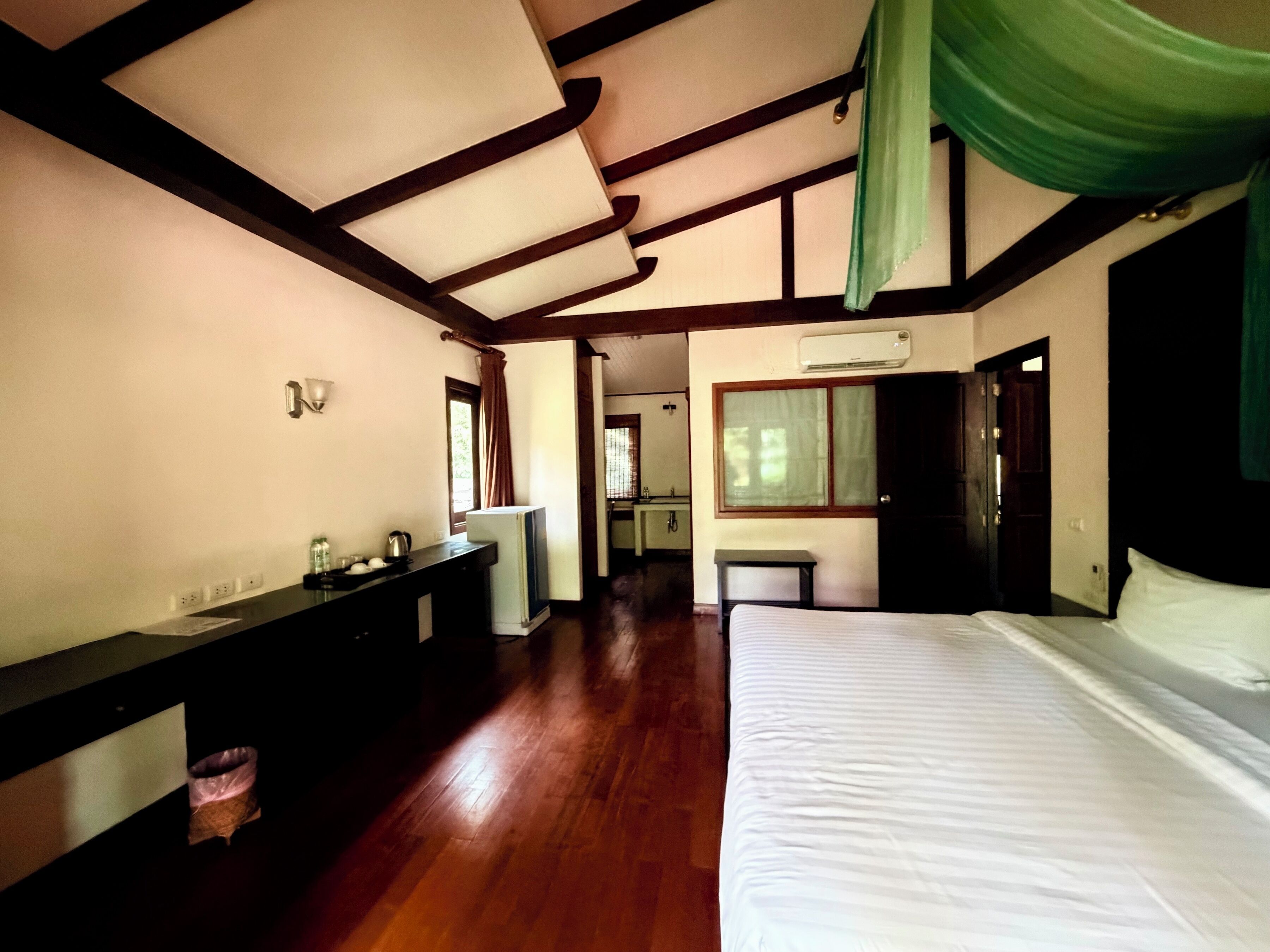 Un dormitorio con cama, cómoda, espejo y ventana.