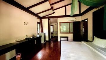 Un dormitorio con cama, cómoda, espejo y ventana.