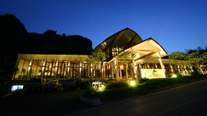 Ein Hotel mit moderner Architektur, das durch einen markanten Eingangsbereich und eine gut beleuchtete Fassade besticht.