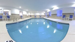 A large indoor swimming pool with clear water, surrounded by lounge chairs and a tiled floor. - Holiday Inn Express Hotel & Suites Albuquerque Airport by IHG (Albuquerque)
