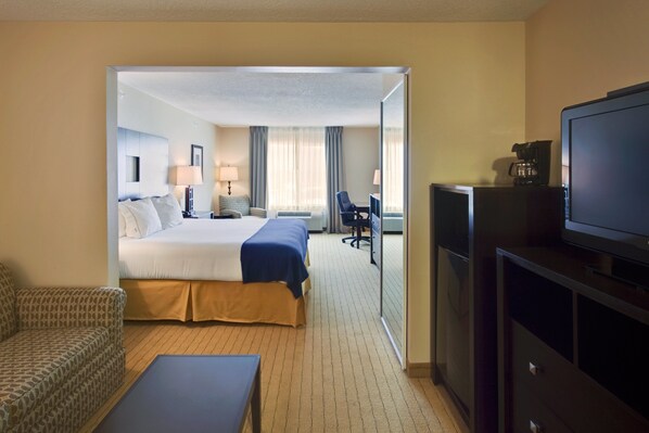 A hotel room with a bed, a desk, a chair, a television, and a coffee maker. - Holiday Inn Express Hotel & Suites Albuquerque Airport by IHG (Albuquerque)