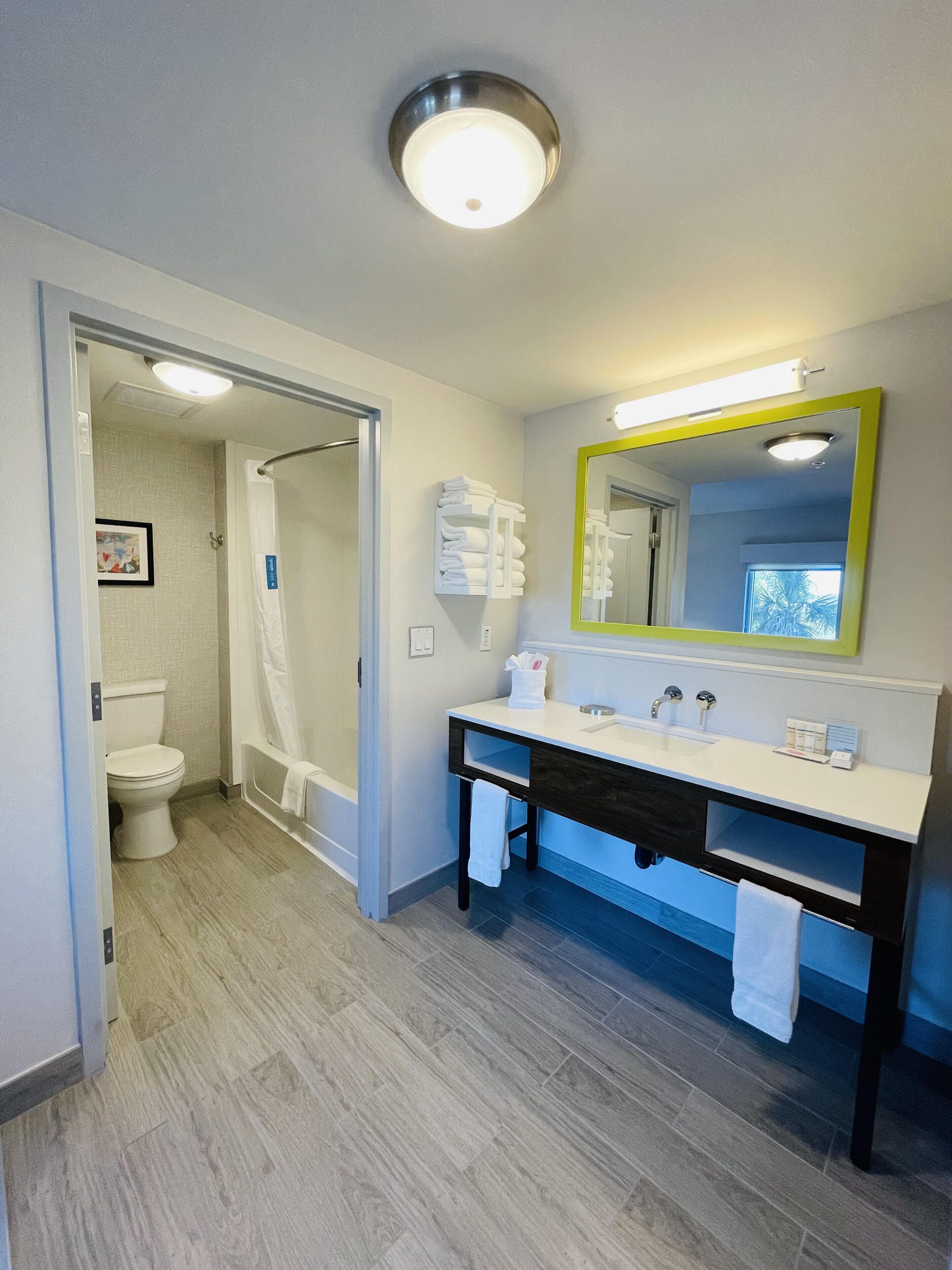 A modern bathroom with a shower, toilet, and sink.