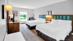 A hotel room with two beds, a desk, a chair, a TV, and a window with a view of greenery. - Hampton Inn & Suites Sarasota/Bradenton-Airport, FL (Sarasota)