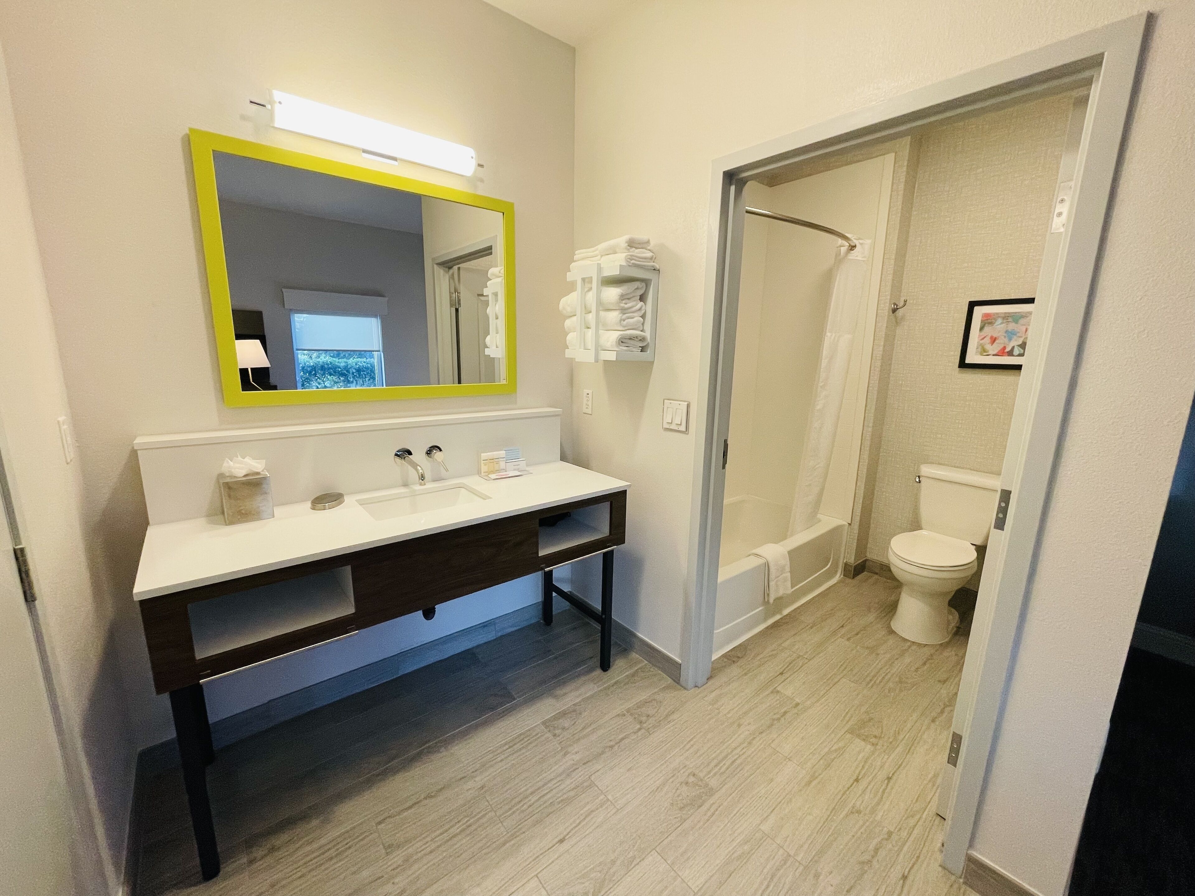 A modern bathroom with a white sink, mirror, and shower.