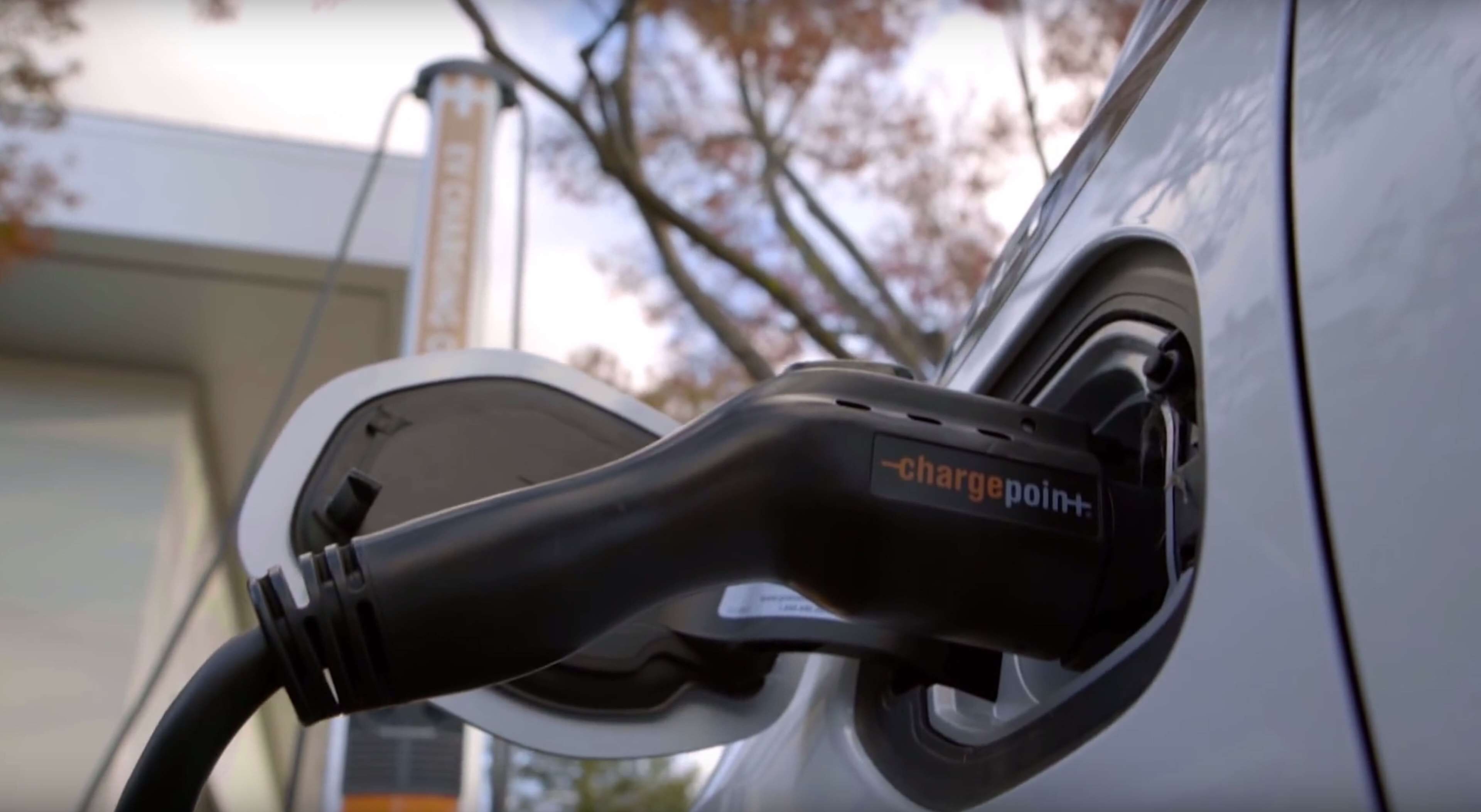 Un automóvil cargando en una estación con la etiqueta "chargepoint+".