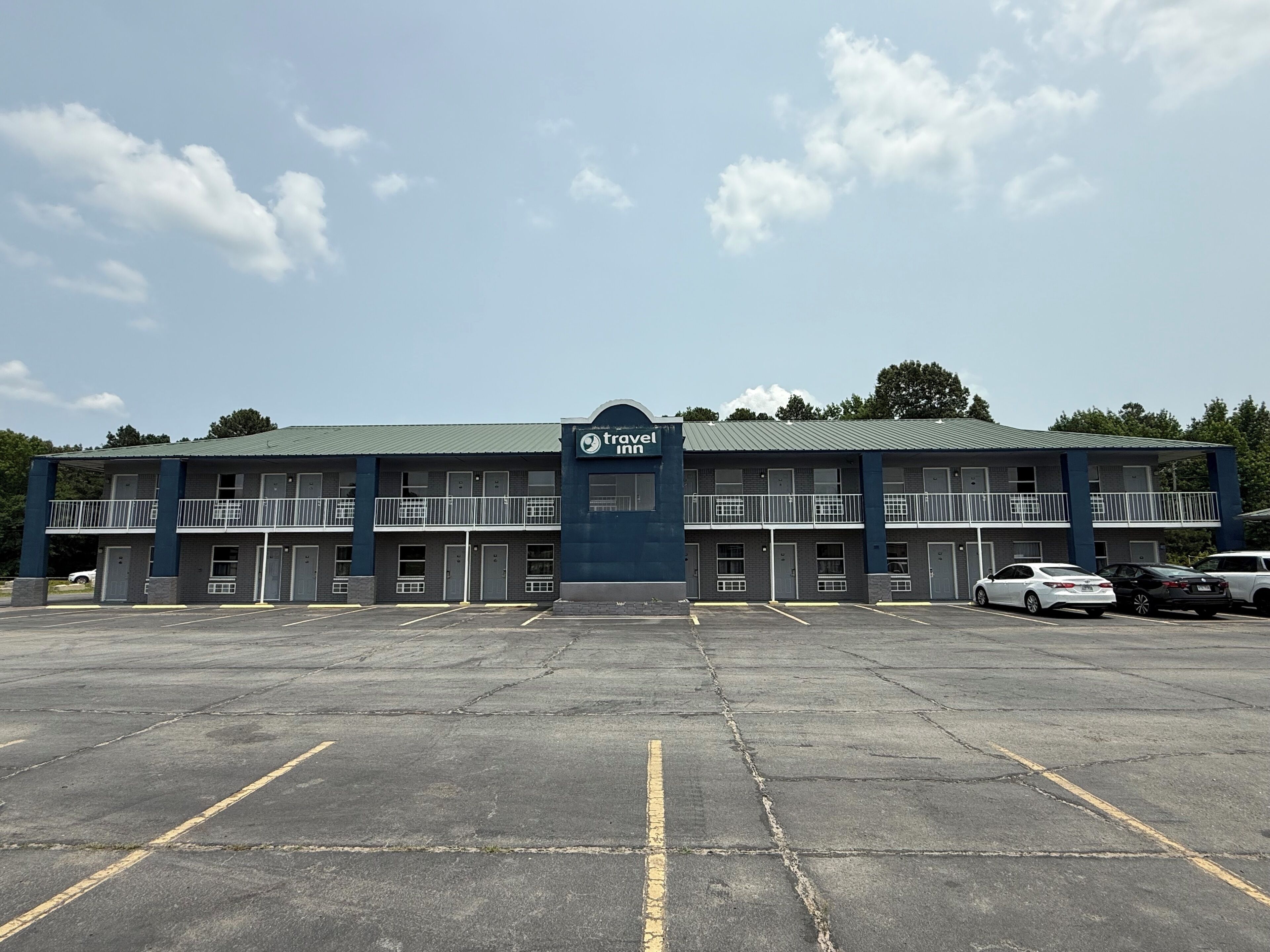 Un Travel Inn de dos pisos, con varios balcones y un estacionamiento.