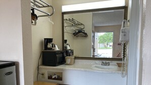 A bathroom with a sink, mirror, and coffee maker. - Travel Inn Hazen (Hazen)