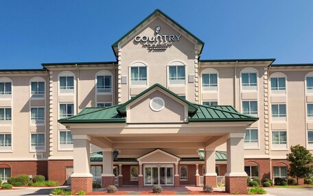 A Country Inn & Suites by Radisson building with a central entrance, multiple windows, and a green roof.