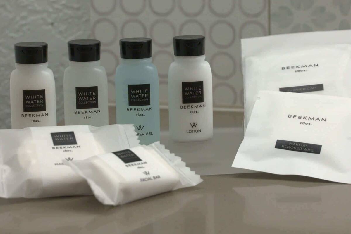 A collection of skincare products from the Beekman brand, including lotion, serum, and a facial scrub.
