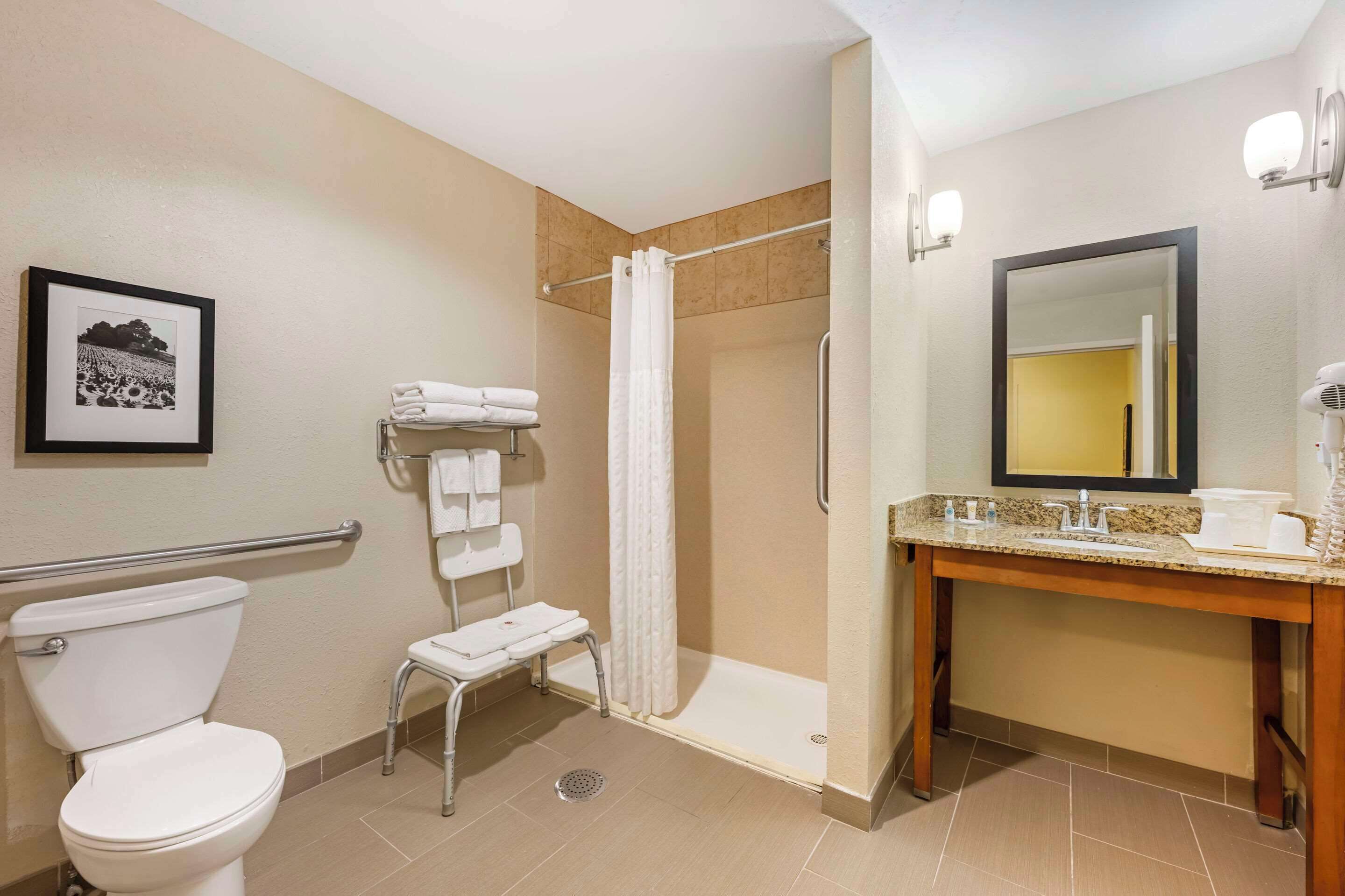 A hotel bathroom with a toilet, shower, and sink.
