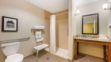 A hotel bathroom with a toilet, shower, and sink.