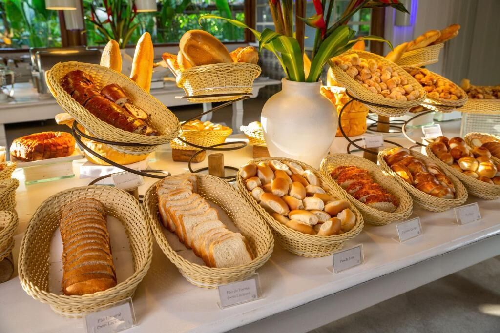 A buffet with various breads and pastries displayed in wicker baskets.