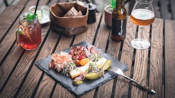 A wooden table with a meal, drinks, and a bottle.