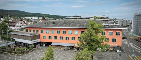 Stylish building with a flat roof, surrounded by a parking area and lush greenery.