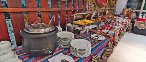 Una mesa de buffet con diferentes alimentos y cubiertos.