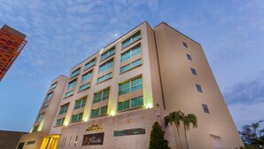 Un moderno edificio de hotel con varios pisos y un cartel llamativo que dice 'Sonesta Hotel Valencia'.