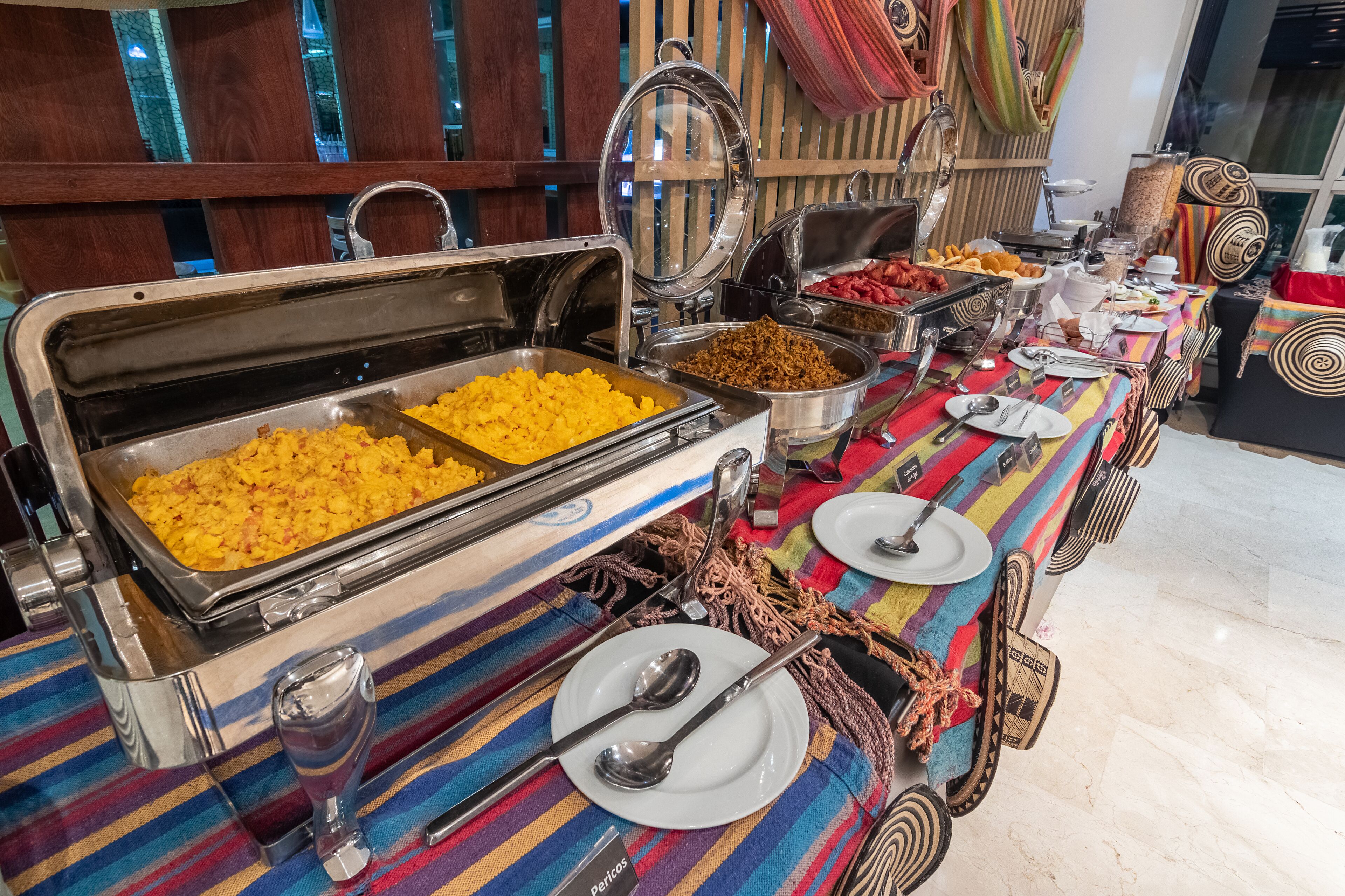 A buffet setup with various food items and utensils.