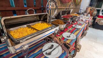A buffet setup with various food items and utensils.