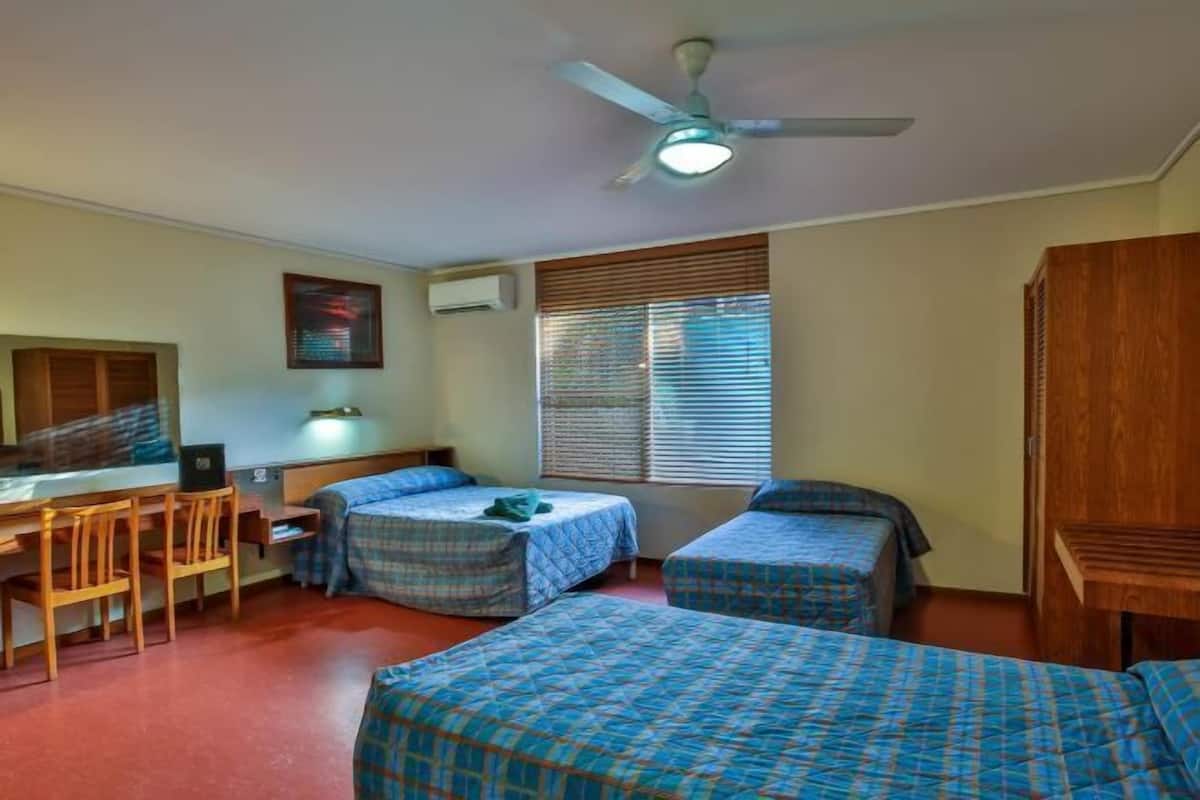 Cozy single room with a single bed, desk, and chair, perfect for work or study.