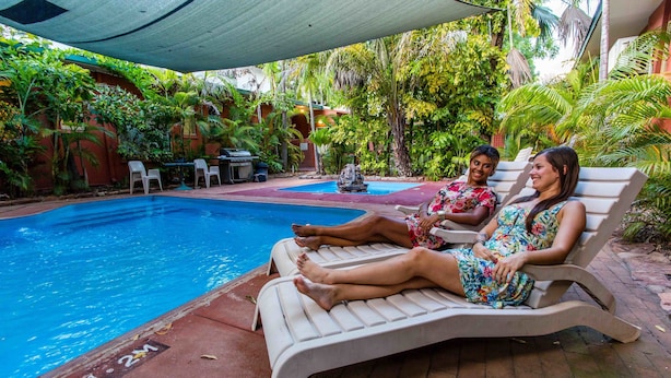 Zona de piscina con sillas de descanso y una pequeña mesa.
