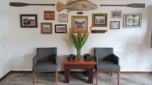 Una habitación con dos sillas, una mesa y un pez montado en la pared.
