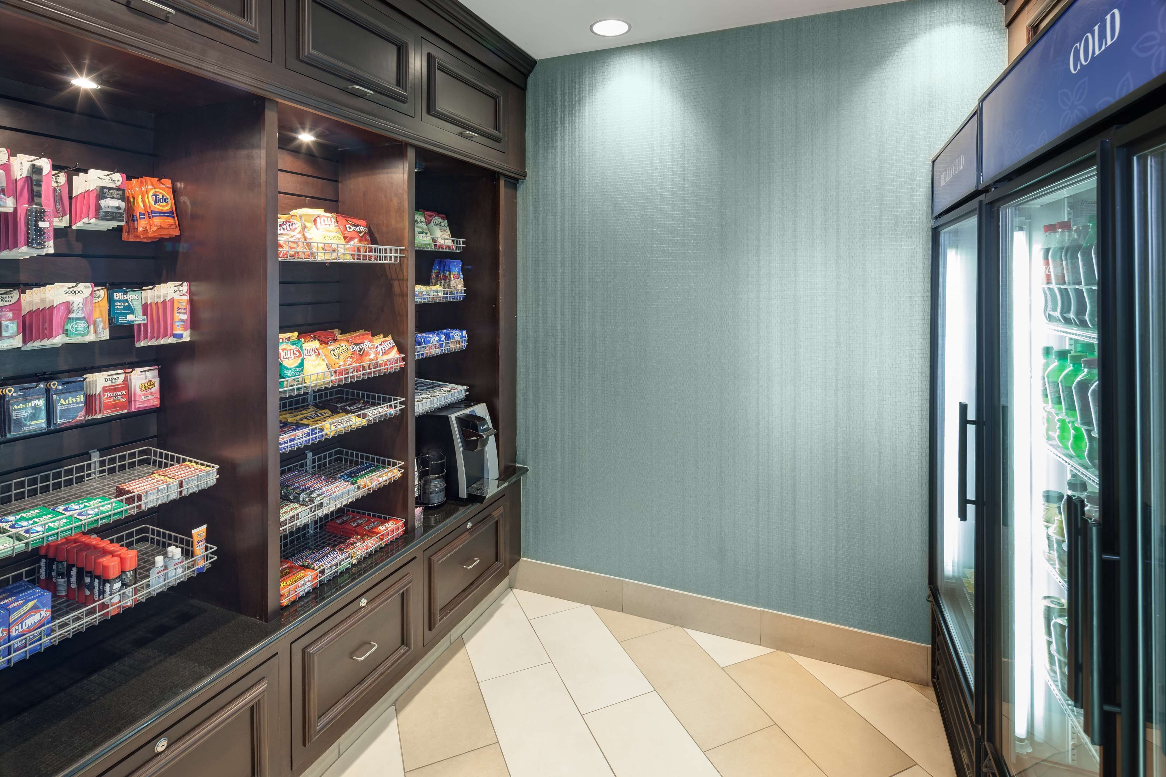 A well-organized pantry with shelves stocked with various food items and a refrigerator on the right.