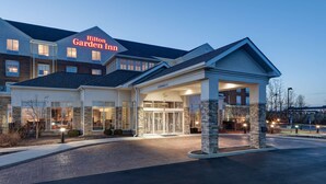 A Hilton Garden Inn with a clear entrance, a well-lit facade, and a brick pathway leading to the entrance.