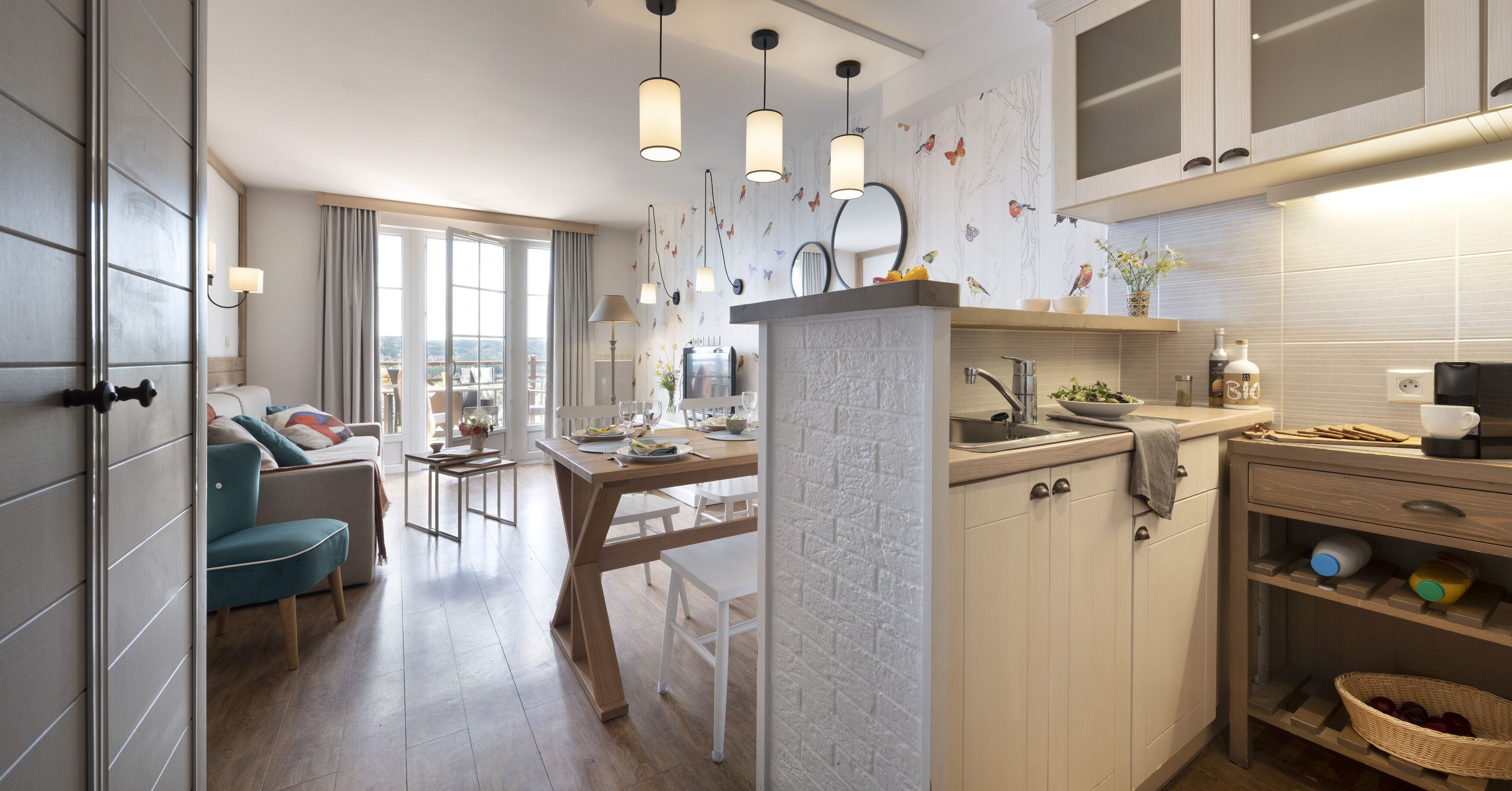 Cocina moderna con comedor, piso de madera y vistas por la puerta de cristal.