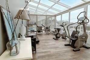 A gym with exercise equipment, a treadmill, and a stationary bike. - Résidence Premium & Spa Houlgate - Pierre & Vacances (Houlgate)