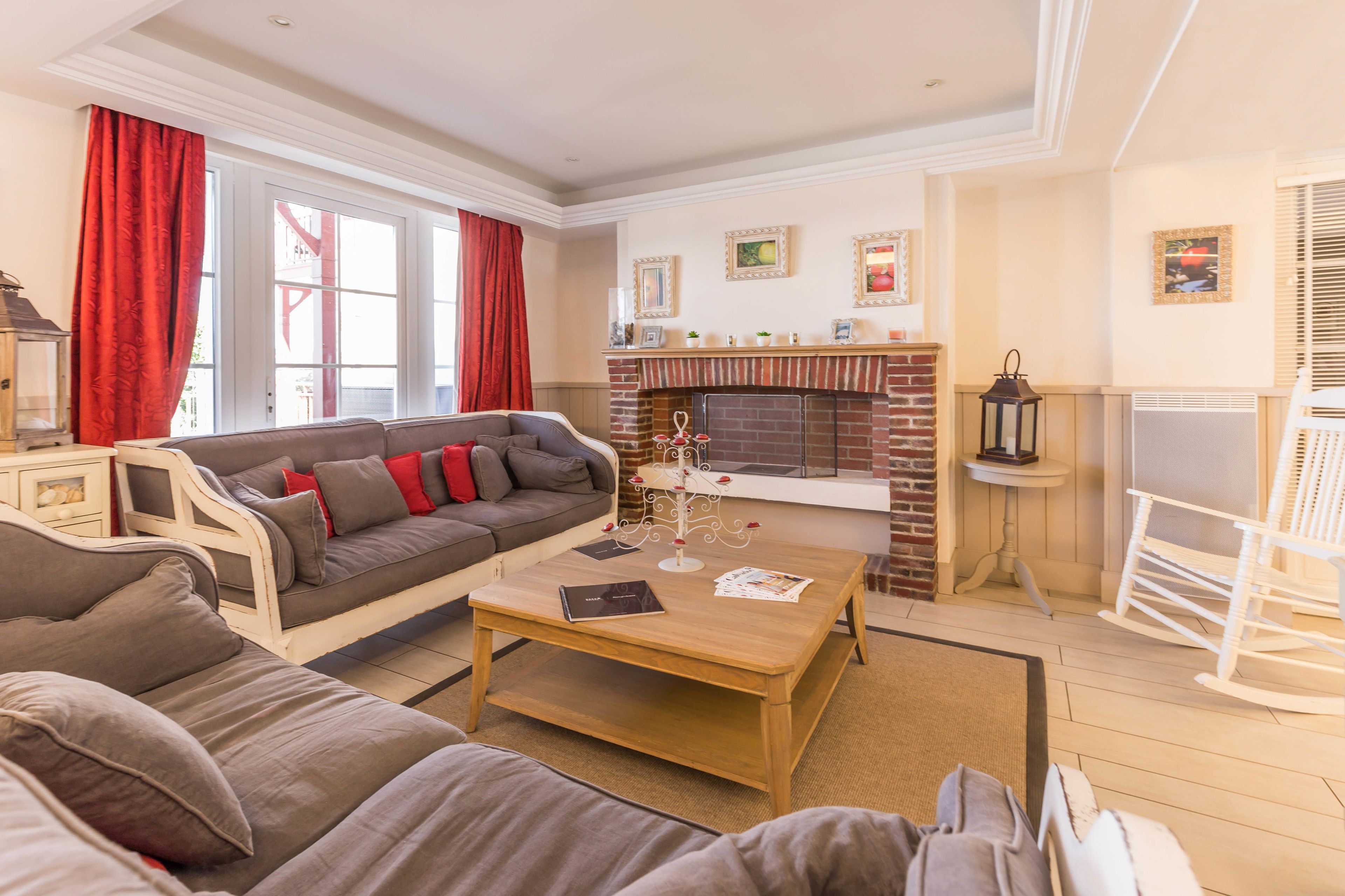 A living room with a sofa, a coffee table, a fireplace, and a rocking chair.