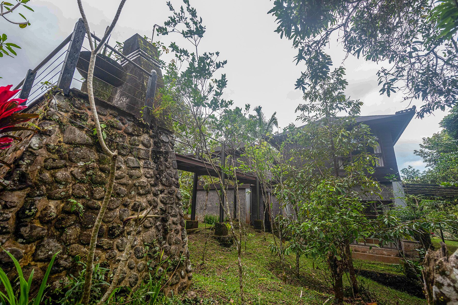 A stone wall, a wooden structure, and a building with a sloped roof.