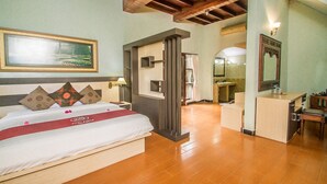 Une chambre d’hôtel avec un lit, un bureau, un miroir et un tableau au mur.