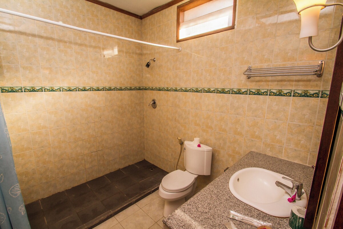 A bathroom with a toilet, sink, and shower.
