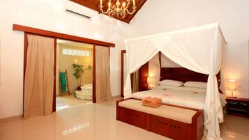 Un dormitorio espacioso con una cama grande, dosel y un banco de madera.