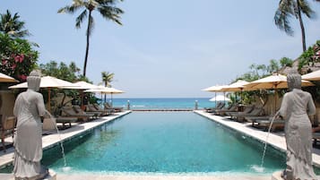 Una piscina al aire libre, sombrillas, sillones reclinables de piscina