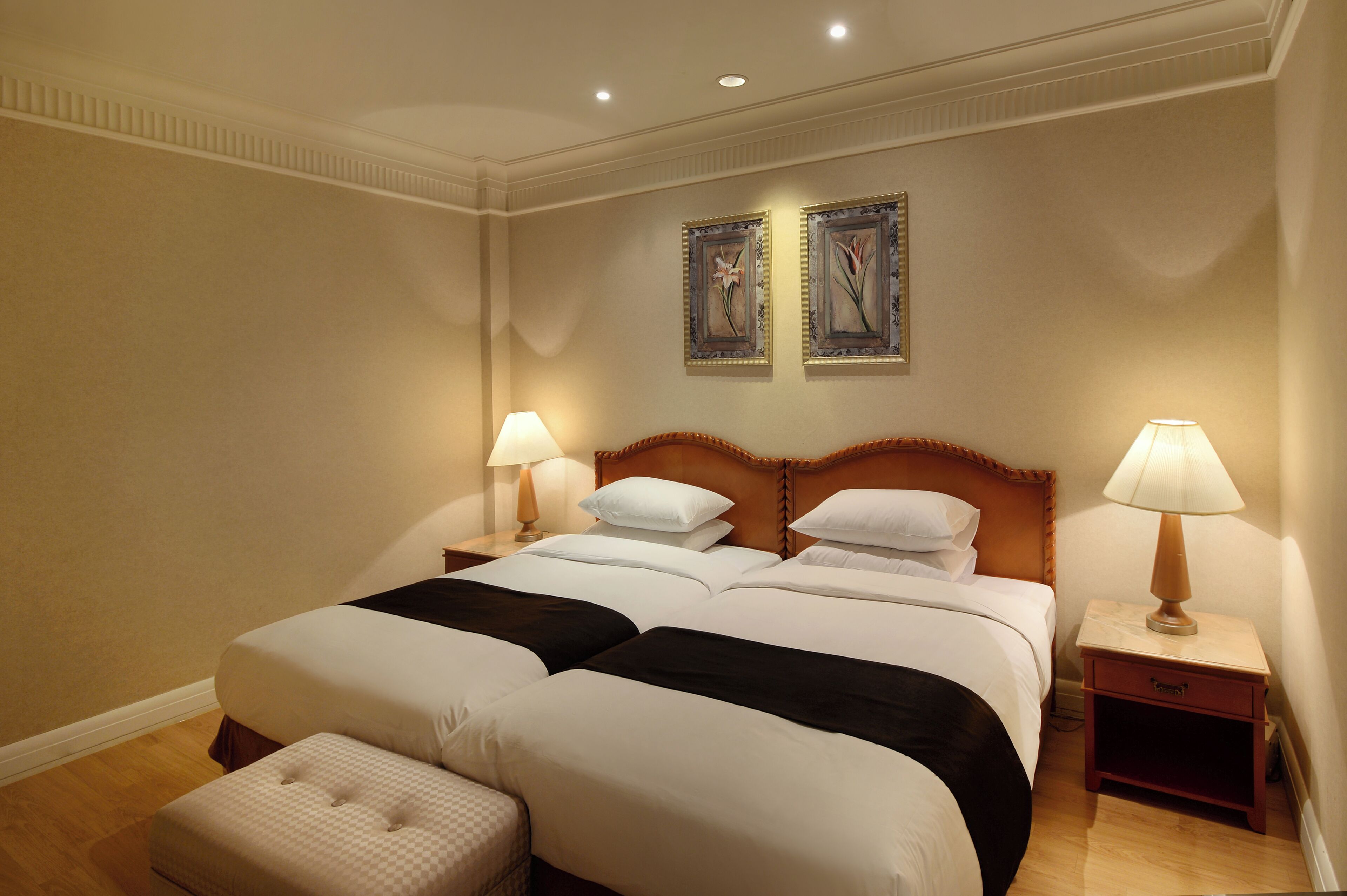 A double bed with two nightstands, each with a lamp, in a hotel room.