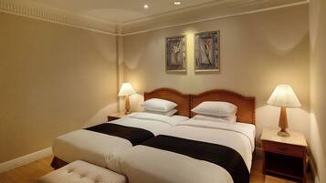 A double bed with two nightstands, each with a lamp, in a hotel room.