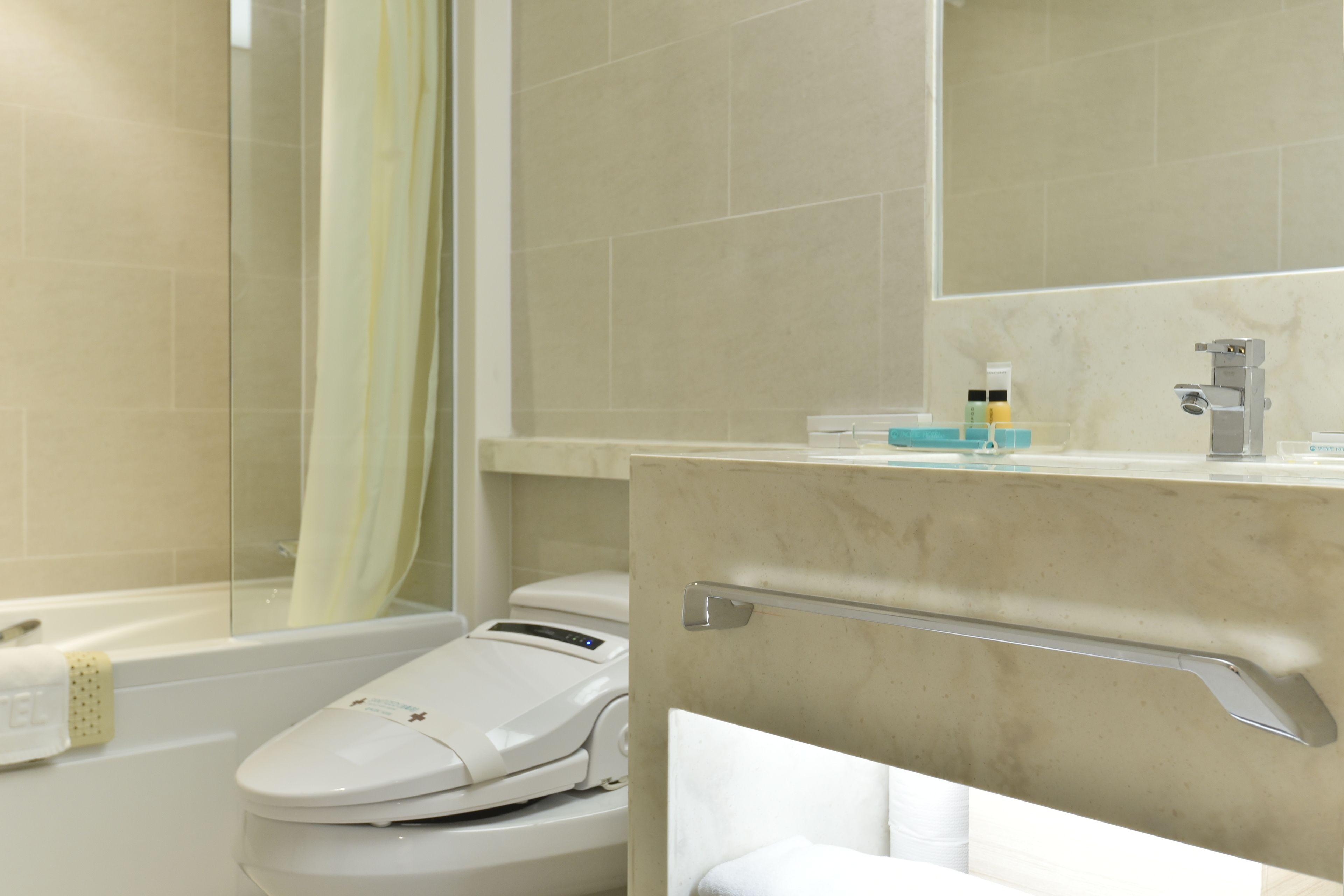 Un baño moderno con bañera, inodoro y zona de ducha.