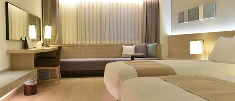 A modern hotel room with a large bed, a desk with a chair, a sofa, and a large window with curtains.