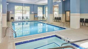 Une piscine intérieure à l’eau claire, aux murs carrelés et aux couleurs bleu et blanc.