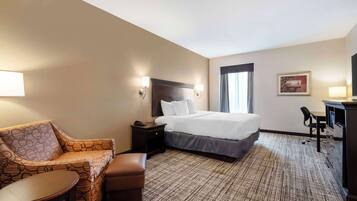 Ein Hotelzimmer mit Bett, Sofa, Schreibtisch und Stuhl.