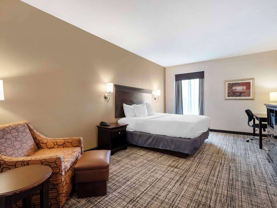 Ein Hotelzimmer mit Bett, Sofa, Schreibtisch und Stuhl.