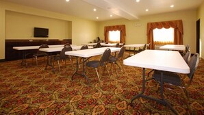 A conference room with multiple tables and chairs, carpeted floor, and a television on the wall. - Best Western Cresson Inn (Cresson)